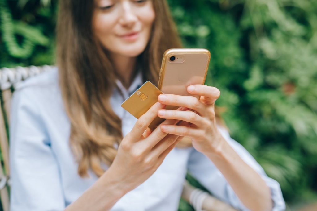 woman shopping online swiping credit card